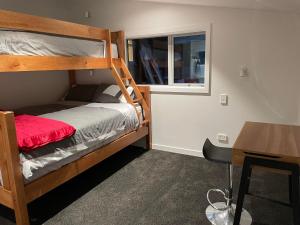 a small room with a bunk bed and a desk at Peninsular Lakefront in Queenstown