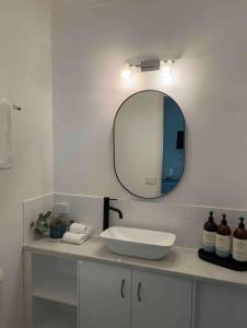 a bathroom with a sink and a mirror at The Queenslander Fullmoon in Port Douglas