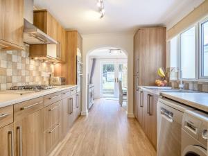a kitchen with wooden cabinets and a large window at Newlands Nook in Weston-super-Mare