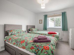 a bedroom with two beds with green sheets and a window at Newlands Nook in Weston-super-Mare