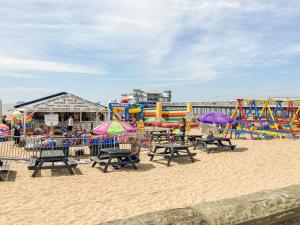 a beach with a playground with chairs and umbrellas at Newlands Nook in Weston-super-Mare