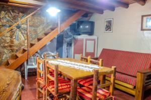 comedor con mesa, sofá y escaleras en La Gaita Alojamiento en San Rafael