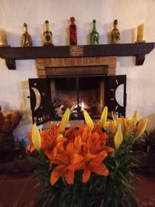 un ramo de flores naranjas frente a una chimenea en LoMar Sol&Luna en Sasaima