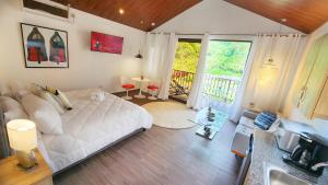 a bedroom with a white bed and a balcony at Rio Verde by Villa Alejandro in Boquete