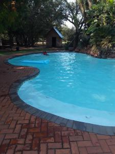 una gran piscina de agua azul en STORGE LODGE AND EVENTS VENUE, en Kroondal