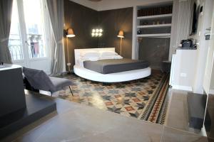 1 dormitorio con 1 cama y 1 silla en Duomo Housing Catania Le Suites, en Catania