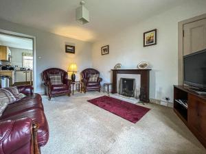 ein Wohnzimmer mit einem Sofa und einem Kamin in der Unterkunft Milton Cottage in Invercassley
