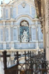 een gebouw met een standbeeld ervoor bij Duomo Housing Catania Le Suites in Catania