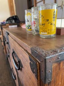 ein Holzschrank mit zwei Gläsern darüber in der Unterkunft KOME HOME in Tōkamachi