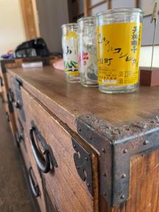 a wooden cabinet with two glasses on top of it at KOME HOME in Tokamachi