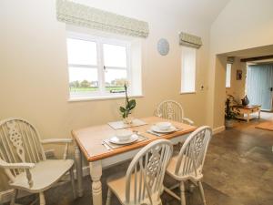 a dining room with a table and chairs and a window at Cow'ouse in Shrewsbury