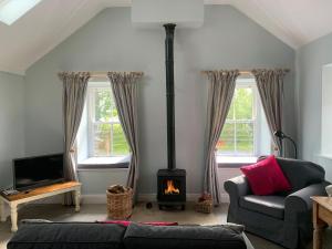 a living room with a fireplace and a couch at Newonstead Bothy in Kirkharle