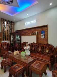 a woman sitting on a bench in a room at Hostel Ngọc Liên in Tuy Hoa