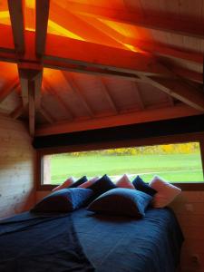 Bett in einem Zimmer mit einem großen Fenster in der Unterkunft La cabane au bain perché 