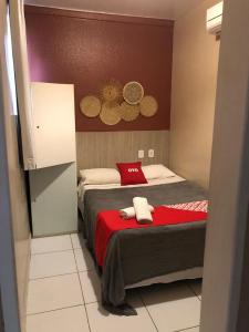 um quarto com uma cama com um cobertor vermelho em Vila da Pajuçara em Maceió