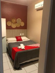 um quarto com uma cama com um cobertor vermelho em Vila da Pajuçara em Maceió