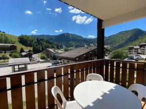 balkon ze stołem i krzesłami oraz góry w obiekcie Appartement 2 Pièces avec Terrasse et Parking, Centre Village à La Clusaz, Proche Pistes et Commerces - FR-1-437-96 w mieście Clusaz