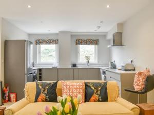 a living room with a couch and a kitchen at Sika Cottage - Uk36194 in Fordingbridge