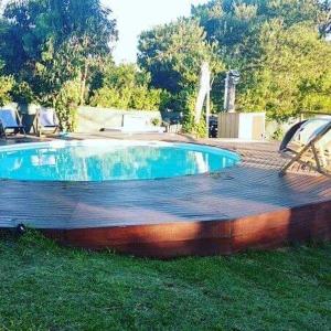 a swimming pool in the grass next to a yard at Luces de la Paloma in La Paloma