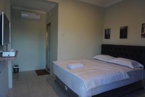 a bedroom with a large bed with white sheets at Alexandria12 Guest House in Selong