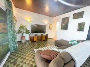 ein Wohnzimmer mit einem Sofa und einem Flachbild-TV in der Unterkunft PK 35 in Apomaoro