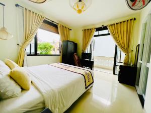 um quarto com uma cama grande e cortinas amarelas em Hoi An Cottage Villa em Hoi An