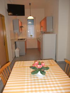 a kitchen with a table with a vase of flowers on it at Apartment U Pošty in Lipova Lazne