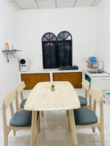 a kitchen with a table and chairs in a room at Chenang's Guest House by Danbam in Kuah