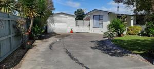 a driveway in front of a house with a fence at Cosy on Courtney in Motueka