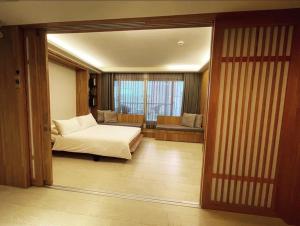 1 dormitorio con 1 cama y 1 habitación con ventana en 台南安平Viva漁樂活民宿 en Anping