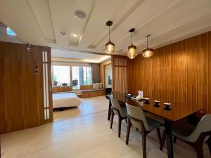 Habitación con mesa, sillas y cama en 台南安平Viva漁樂活民宿 en Anping