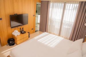 um quarto com uma cama e uma televisão de ecrã plano em 台南安平Viva漁樂活民宿 em Anping
