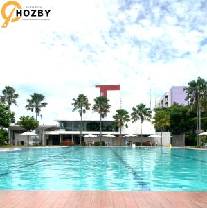 een groot zwembad voor een gebouw bij Hozby Suites Aeropolis Premier in Teko