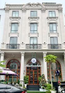 a white building with a sign on the front of it at Ballantine hotel in Ho Chi Minh City
