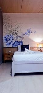 a bedroom with a white bed with a painting on the wall at Phi Phi Indigo Hotel in Phi Phi Don