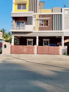 a house with a red fence in front of a street at luxury home in Vadavalli in Coimbatore