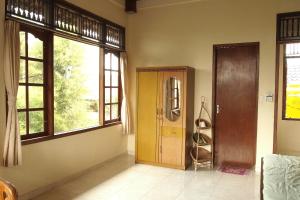
a room with a bed, a window, and a door at Runa Guesthouse in Ubud
