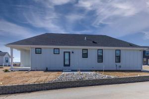 a white house with a black roof at Charming 3-bedroom in vibrant new neighborhood in Billings