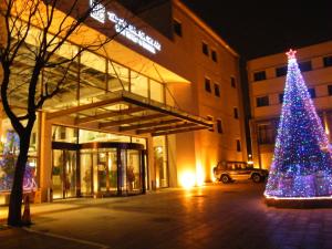 Un árbol de Navidad delante de un edificio en Jianguo Hotspring Hotel, en Beijing