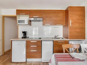 - une petite cuisine avec des appareils blancs et des armoires en bois dans l'établissement Appartement Luz-Saint-Sauveur, 3 pièces, 6 personnes - FR-1-402-75, à Luz-Saint-Sauveur