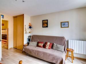 Una sala de estar con un sofá en una habitación. en Studio cabine à Esquièze-Sère pour 6 avec balcon, vue montagne et parking - FR-1-402-34, en Esquièze - Sère