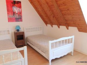 een slaapkamer met 2 witte bedden en een houten plafond bij Maison Fouesnant, 5 pièces, 8 personnes - FR-1-481-47 in Fouesnant