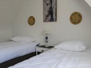 two beds in a hotel room with white sheets at Maison de charme 3* avec WIFI, jardin clos, véranda, à 350m du port à Perros-Guirec - FR-1-368-254 in Perros-Guirec