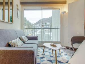 un salon avec un canapé et une grande fenêtre dans l'établissement Studio 4 personnes Résidence Ayre - FR-1-403-95, à Barèges