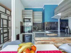 une cuisine avec une table avec un bol de fruits dessus dans l'établissement Studio 4 personnes Résidence Ayre - FR-1-403-95, à Barèges