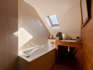 un baño con bañera y lavabo en Maison spacieuse pour 11 pers. avec terrasses et jardin à Vielle-Aure - FR-1-296-335, en Vielle-Aure