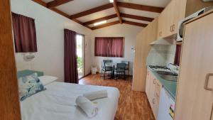 a bedroom with a bed and a kitchen with a sink at Freedom Lifestyle Parks Goondiwindi in Goondiwindi