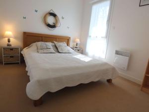 a bedroom with a large bed with two pillows on it at Triplex cosy à Bénodet : Terrasse, Jardin, Plage et Thalasso à 200m ! - FR-1-481-104 in Bénodet