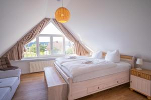 um quarto com uma cama grande e uma janela grande em Ferienhaus "Seeadler" in Rankwitz am Peenestrom em Rankwitz