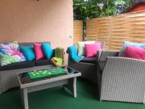 un patio con 2 sofás de mimbre y una mesa en Relax Nyaraló Dombori, en Fadd-Dombori